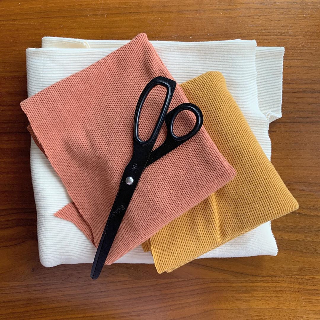 Scissors sitting on top of fabric